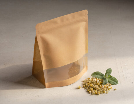 Unbranded brown paper tea pouch mockup with transparent window on concrete background