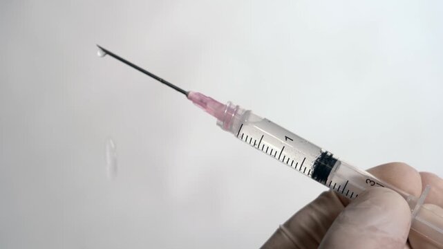 A close-up view of a syringe filled with a clear liquid, showcasing the needle and.