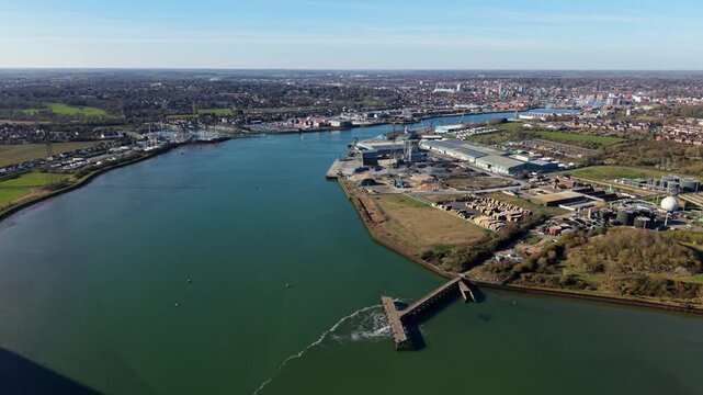 Panning aerial view of Ipswich harbour and Orwell Estuary showing wastewater treatment outfall discharging water