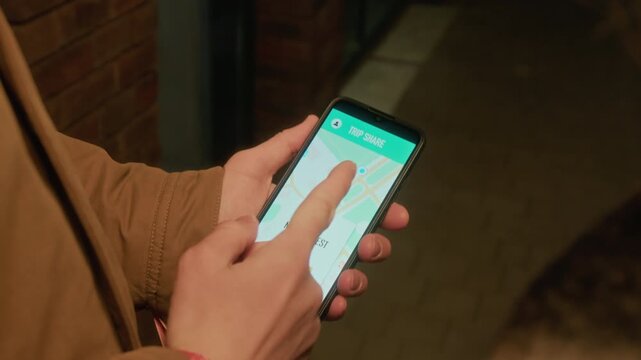 Hands of unrecognizable man holding smartphone and accepting ride-sharing request on screen, over shoulder shot. Video is ideal for gig economy and mobile app marketing