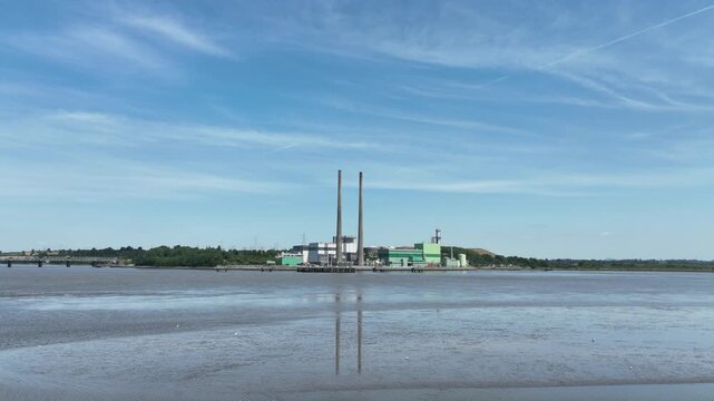 Professional drone video of power generation infrastructure on the River Suir, Wexford, Ireland. electricity facility with flowing water and rural landscape under natural daylight.