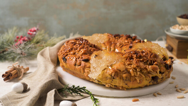 Traditional Portuguese Bolo Rei Christmas cake decorated with nuts and candied fruit on a festive holiday table