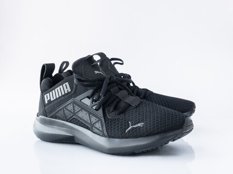 Black Puma Softride Enzo Nxt running shoes with geometric TPU cage, on a clean white reflective surface