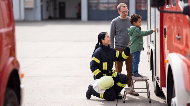 Junge dr&uuml;ckt Knopf am Feuerwehrauto auf der Feuerwache