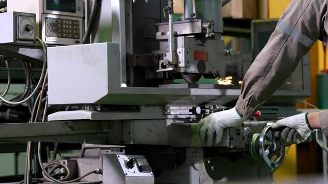 Machinist engineer grinder workshop metal machine spark glove factory industrial worker operating control equipment adjusting machinery manufacturing plant focused posture