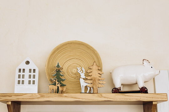 Wooden Christmas decor and figurines placed on a shelf in a simple room