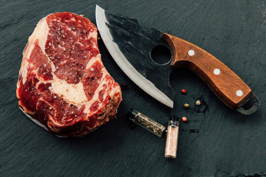 Fresh cut beef with a knife and spices ready for cooking