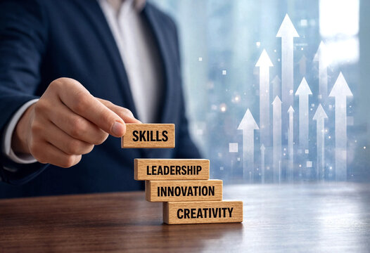 Business professional placing wooden block labeled skills on top of leadership innovation and creativity blocks