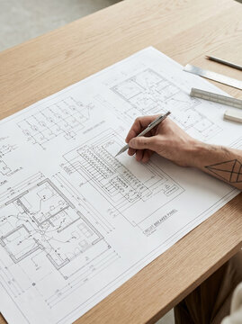 High Angle Close-Up View of Electrical Engineer Drafting Circuit Breaker Panel Wiring Blueprint on Wooden Desk with Pencil