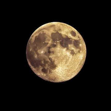 Detailed closeup view of a full moon with visible craters and textures in night sky