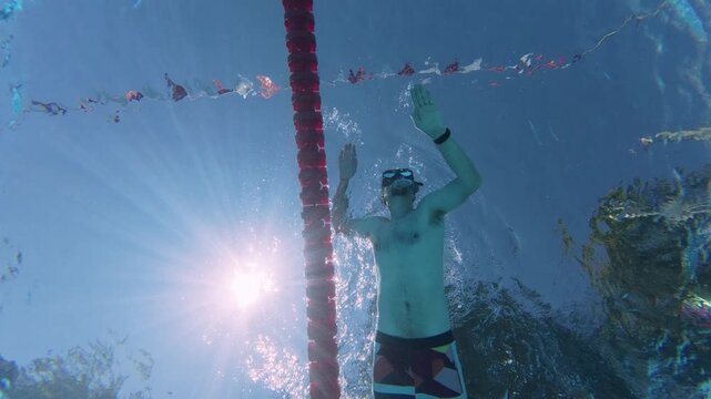 Low Angle Underwater View of Man Swimming with Fins in Pool