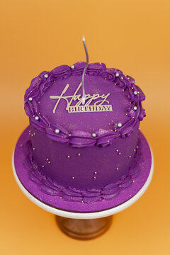 Purple birthday cake celebrating with candle and topper