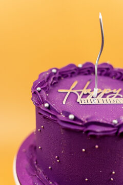 Purple birthday cake celebrating happy occasion with candle