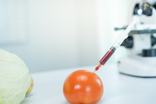 Scientist check chemical food residues in laboratory. Control experts inspect quality of fruit, scientists inject chemicals into apples for experiments, hazards, prohibited substance, contaminate