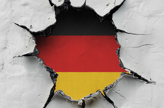 national flag of Germany is painted on an old wall with cracks