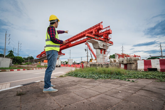 Asian workers are employed at a construction site for a new concrete bridge, a crucial infrastructure project for heavy urban transportation and bypass roads.