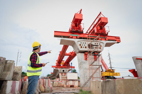 Asian workers are employed at a construction site for a new concrete bridge, a crucial infrastructure project for heavy urban transportation and bypass roads.