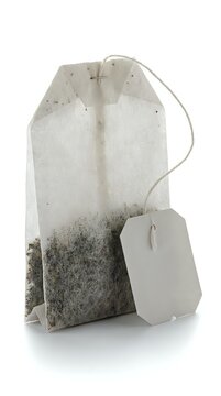 Single tea bag with string, label, and visible dried tea leaves