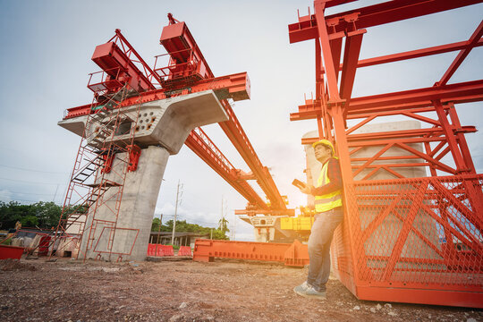 Asian workers are employed at a construction site for a new concrete bridge, a crucial infrastructure project for heavy urban transportation and bypass roads.