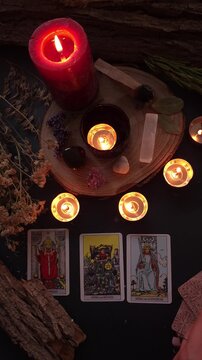 hand reading tarot cards by candlelight on rustic table, exploring mysteries and spirituality