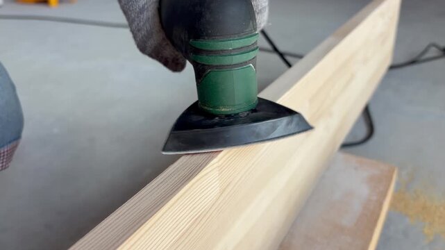 man sanding a board with a sanding machine. Renovation, carpentry