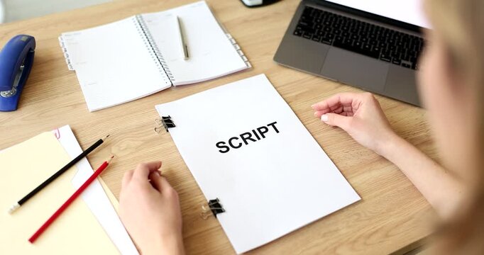 In a bright and inviting workspace, a person focuses on writing a script. Surrounded by pens, notebook, and a laptop, the atmosphere buzzes with inspiration and ideas.