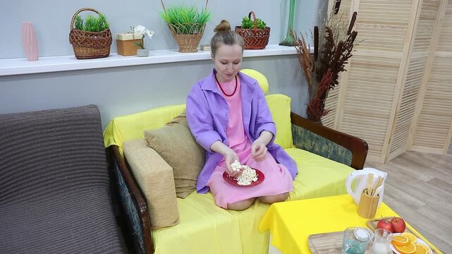 woman eats popcorn by the handful