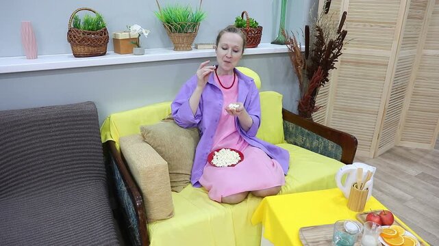 woman eating popcorn from a handful and talking