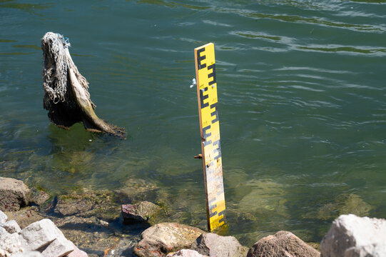 Gauge board, measure water levels in rivers or canals, yellow scale with black numbers and markings, measuring instrument for drought or flood forecasting, waterway management