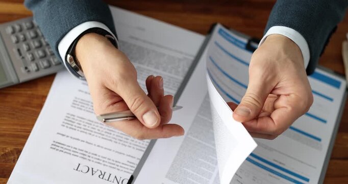 In a vibrant office, confident hands sift through crisp papers, showcasing diligence and attention to detail while preparing for a crucial discussion.
