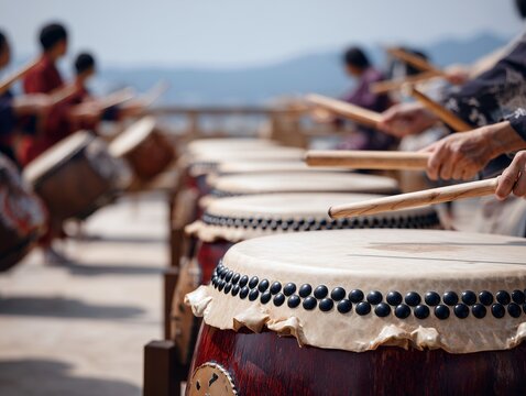 晴天の下で行われる迫力ある和太鼓の演奏で撥を振るう奏者たちの躍動感あふれる風景