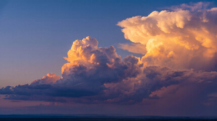 Majestic cloudscape at sunset above a wide expansive landscape with dramatic cumulus formations and vivid colors.
