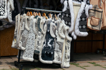 fur vest winter clothing warm outerwear fluffy wool fabric white grey texture traditional market display concept of slovak culture, fashion, retail © Lana Pietukhova