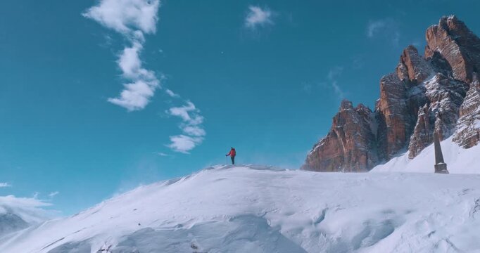 Aerial footage of a ski mountaineer in a snowy alpine ridge in Dolomites. Winter landscape, backcountry adventure, and solitude in breathtaking mountain scenery captured in 4K.
