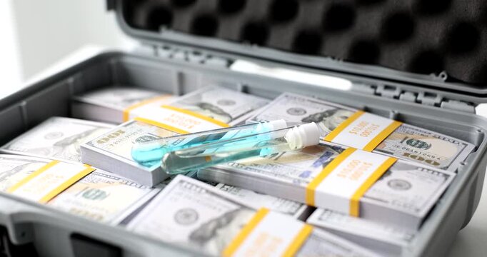 In a dimly lit room, a sturdy case opens to show bundles of cash neatly arranged alongside a strange syringe. The discovery raises questions about its purpose.