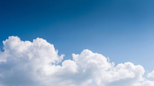 Clear blue sky with soft white cumulus clouds stretching across the horizon, perfect for peaceful and airy designs.