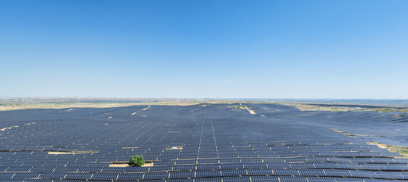 Endless Solar Panel Field Stretching Across Desert Landscape Under Blue Sky
