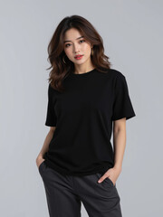 Obraz premium Woman portrait black shirt gray pant studio casual fashion standing hand in pocket, calm young woman in casual outfit against gray background