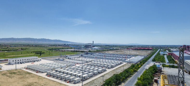 Aerial View of Large Battery Energy Storage Station near Industrial Zone and Mountains