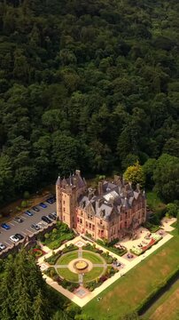 Rising 60FPS vertical social ratio aerial video of Belfast Castle and Cavehill in North Belfast, Northern Ireland in the UK on a bright sunny day. Produced with Rec709 colour.