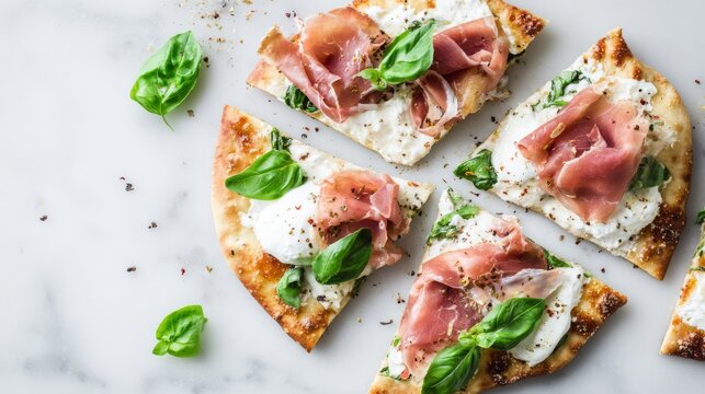 Fresh homemade flatbread pizza slices topped with prosciutto, ricotta, and basil