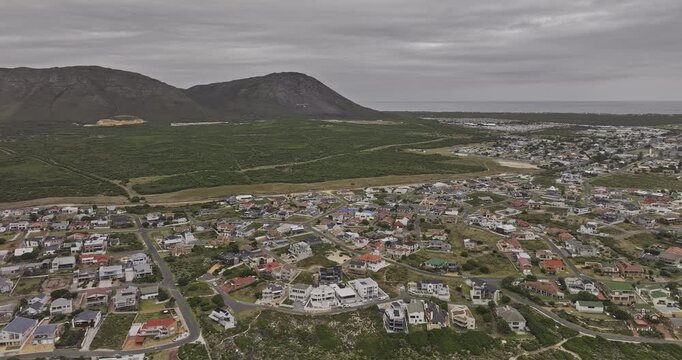 Gansbaai South Africa Aerial v6 high overcast flyover above the shoreline, residential neighborhoods and coastal townscape - Shot with Mavic 3 Pro Cine - Jan 7th 2024