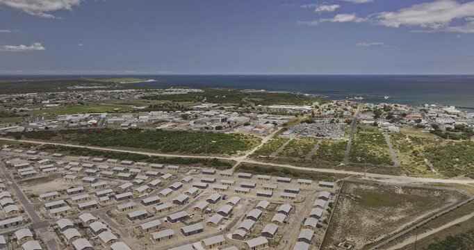 Gansbaai South Africa Aerial v20 flyover above township housing and an industrial area toward residential townscape and the coastal harbor - Shot with Mavic 3 Pro Cine - Jan 8th 2024