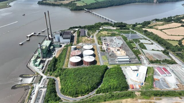 static aerial power station on banks of river,Ultra HD aerial footage of electricity generating station on the River Suir, Wexford. infrastructure with tranquil river, green countryside