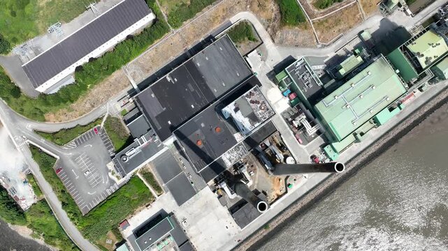 Ariel above and over power station on the River Suir, Wexford, Ireland. High-definition aerial footage highlighting clean energy and rural environment.