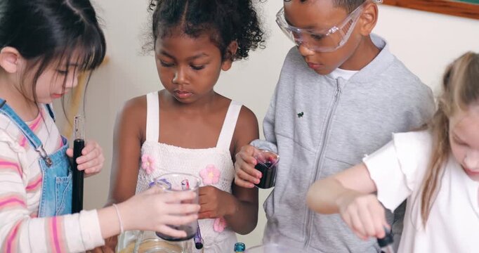 Diverse young children conduct a colorful chemistry experiment using test tubes and pipettes in a classroom.