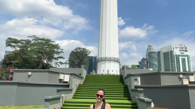Woman tourist posing in front of KL Tower Kuala Lumpur Malaysia tall landmark