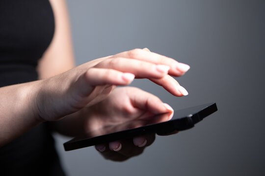 A young woman  holds a smartphone in her hands