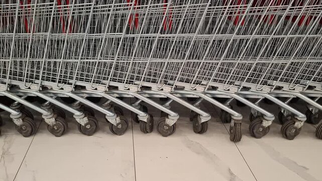 Rows of nested shopping carts outside a retail store, supermarket equipment, consumer commerce, and everyday shopping.