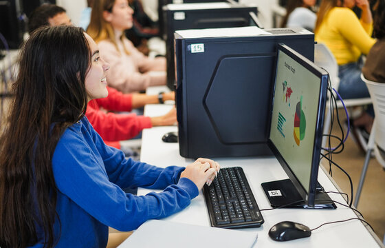 Young students using computers inside technology AI business class at school university room - Back to school, technology and education concept - Focus on girl hands